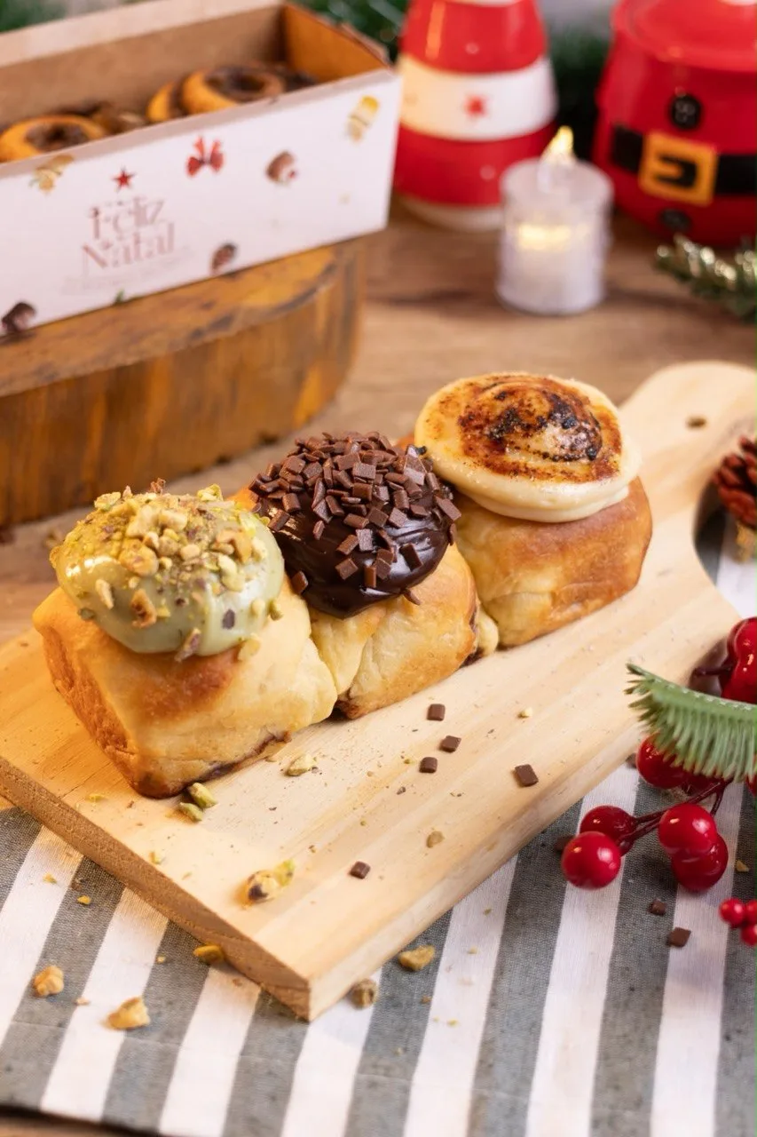 Mini panetones recheados com cobertura de pistache, chocolate e creme em tábua de madeira