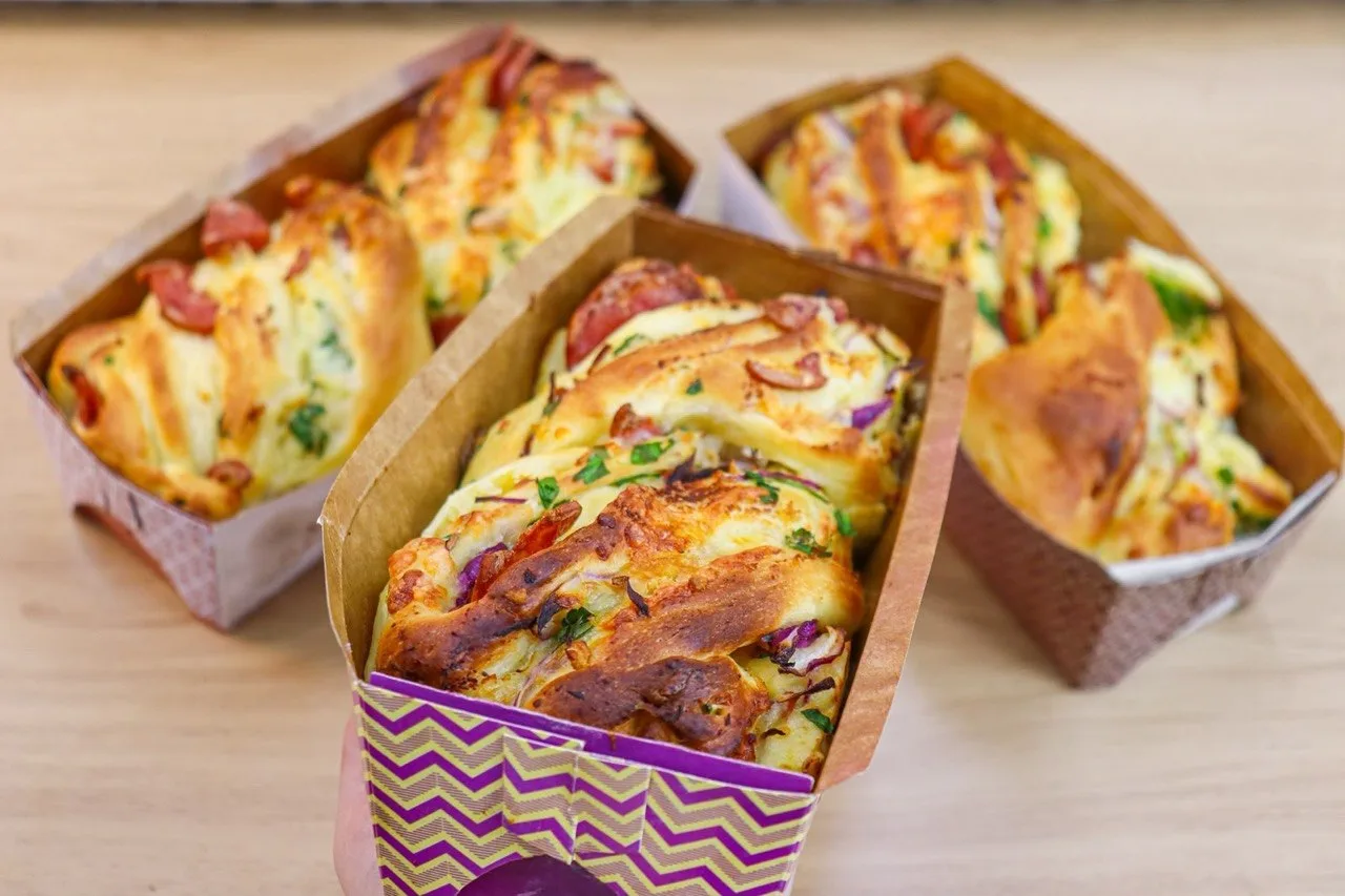 Panetones salgados trançados com calabresa e cheiro-verde em forminhas de papel
